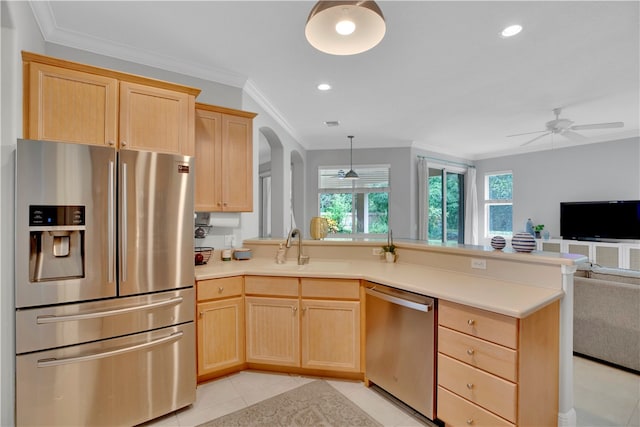 kitchen with light brown cabinets, ceiling fan, crown molding, and stainless steel appliances