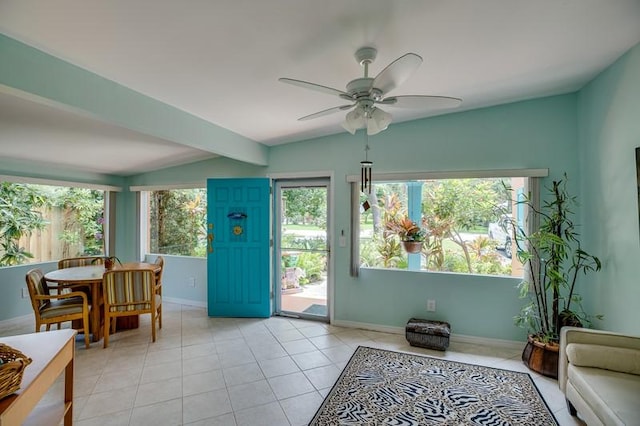 interior space with ceiling fan, light tile patterned floors, and lofted ceiling