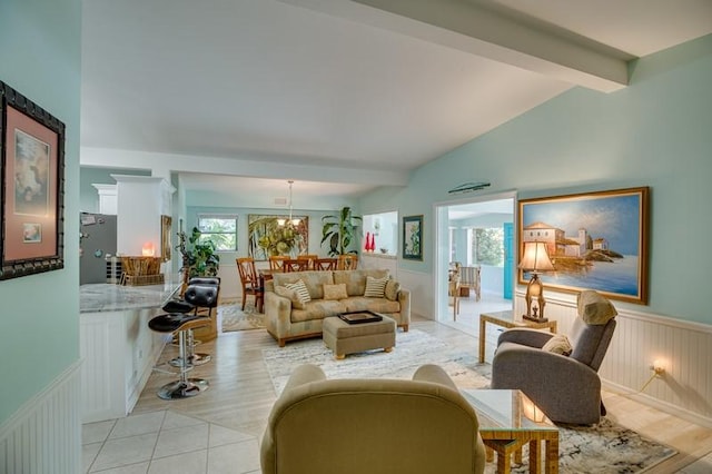 living room with light wood-type flooring, lofted ceiling with beams, and an inviting chandelier