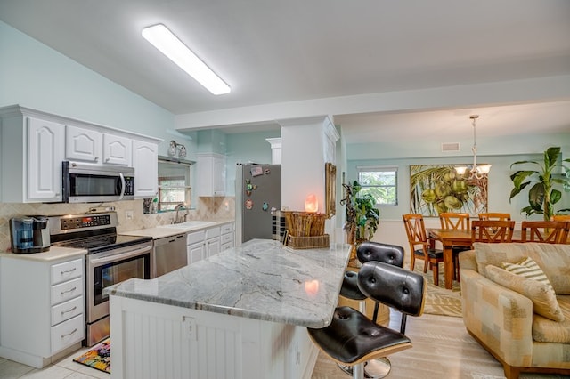 kitchen with hanging light fixtures, sink, appliances with stainless steel finishes, and tasteful backsplash