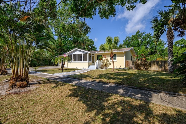 ranch-style house with a sunroom and a front yard