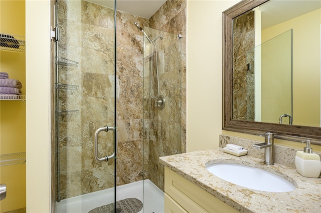 bathroom with vanity and a shower with door