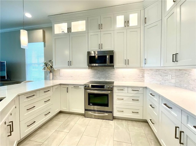 860 Saint James Ln, Vero Beach, FL 32967 - kitchen with stainless steel appliances, light countertops, backsplash, ornamental molding, and hanging light fixtures