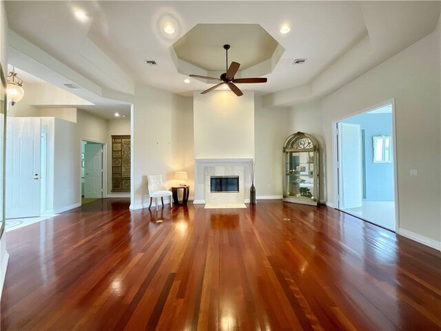 860 Saint James Ln, Vero Beach, FL 32967 - unfurnished living room featuring wood finished floors, ceiling fan, a fireplace, a tray ceiling, and baseboards