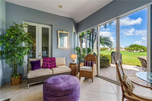 living area with light tile patterned floors, ceiling fan, and french doors