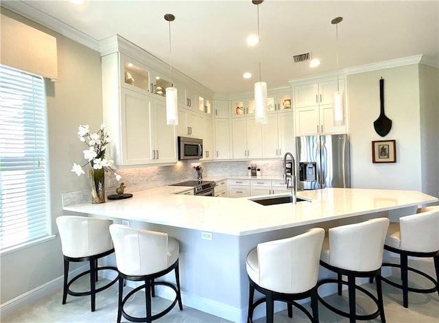 kitchen with stainless steel appliances, white cabinetry, hanging light fixtures, and sink