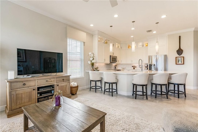 kitchen featuring white cabinetry, crown molding, decorative light fixtures, appliances with stainless steel finishes, and decorative backsplash