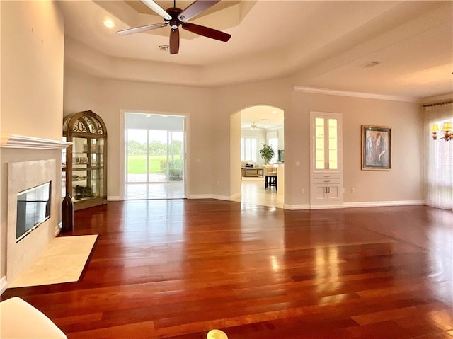860 Saint James Ln, Vero Beach, FL 32967 - unfurnished living room with arched walkways, wood finished floors, ceiling fan, a fireplace, and a chandelier