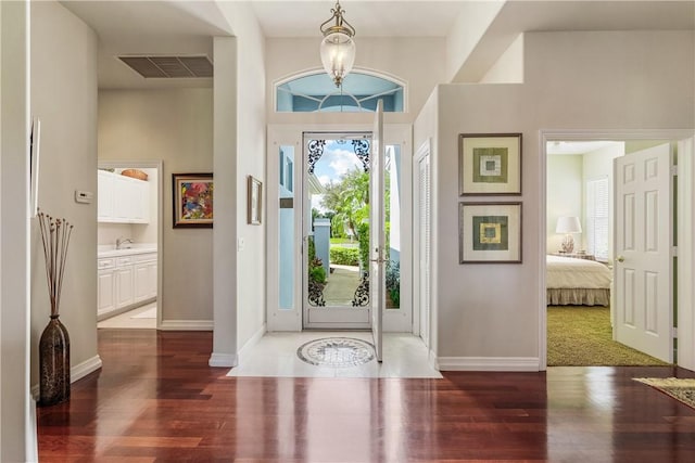 foyer with dark wood-type flooring and a chandelier