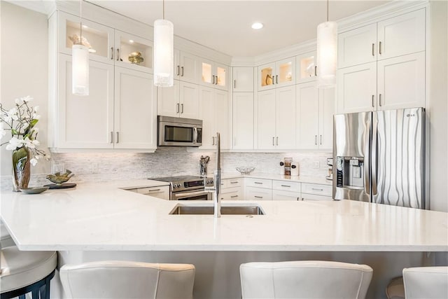 kitchen featuring stainless steel appliances, white cabinetry, and a breakfast bar