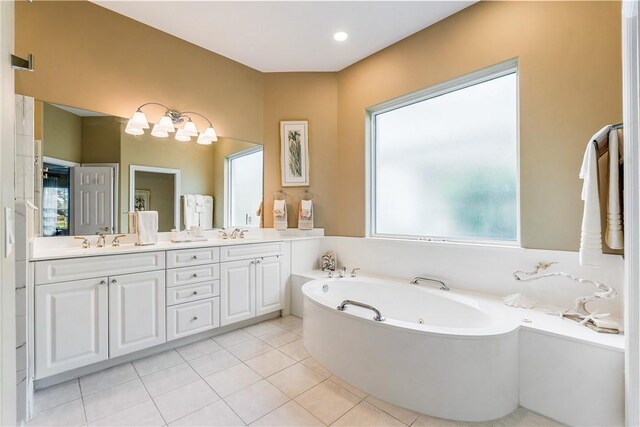 bathroom featuring a notable chandelier, vanity, tile patterned flooring, and a washtub