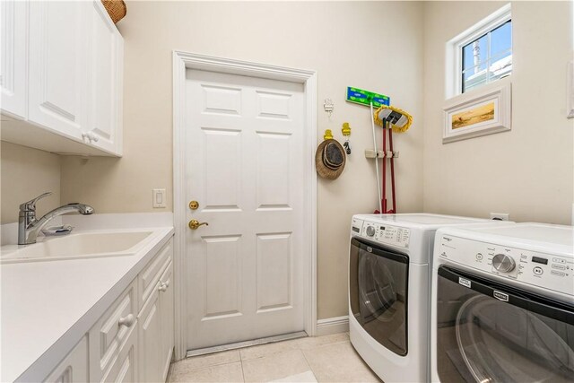 laundry area featuring washer and dryer, sink, light tile patterned floors, and cabinets