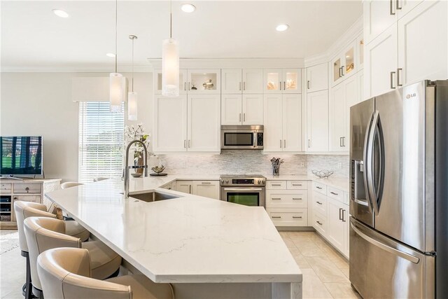 interior space featuring sink, ornamental molding, pendant lighting, light stone countertops, and white cabinets