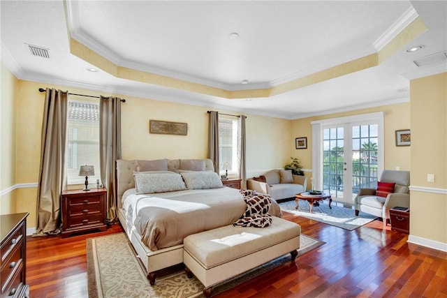 bedroom featuring dark hardwood / wood-style flooring, a raised ceiling, and ornamental molding