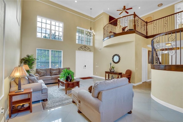 living room featuring ceiling fan with notable chandelier, light tile patterned floors, a high ceiling, and ornamental molding