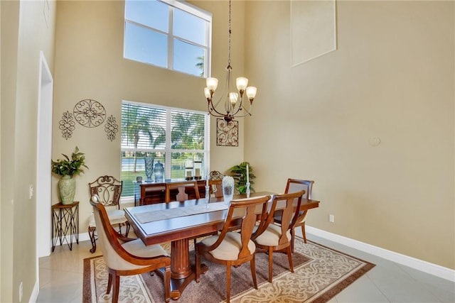 tiled dining room with a high ceiling and an inviting chandelier