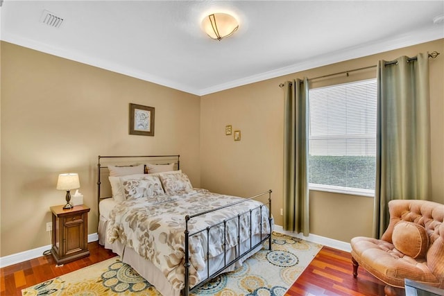 bedroom featuring crown molding and dark wood-type flooring