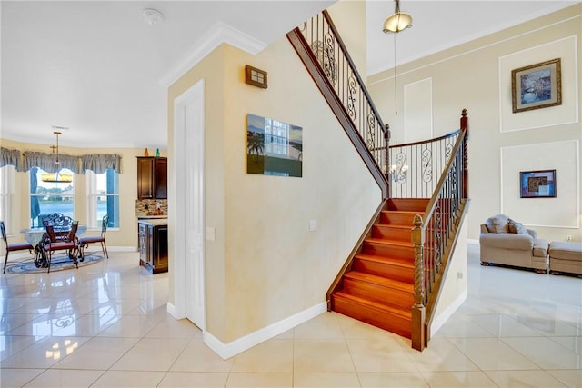 stairs with tile patterned flooring and crown molding