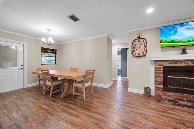 1966 9th St, Vero Beach, FL 32960 - dining area with a chandelier, wood finished floors, ornamental molding, recessed lighting, and a fireplace