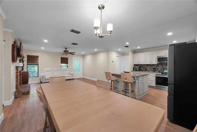 1966 9th St, Vero Beach, FL 32960 - dining room featuring ornamental molding, light wood finished floors, ceiling fan, recessed lighting, and a chandelier