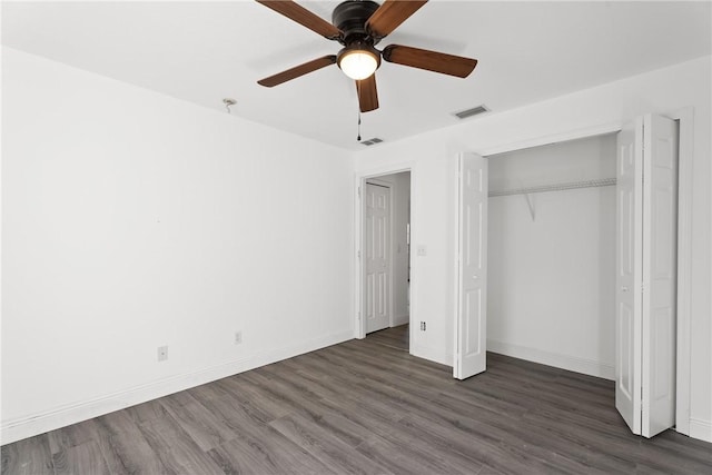 unfurnished bedroom with ceiling fan, dark hardwood / wood-style flooring, and a closet