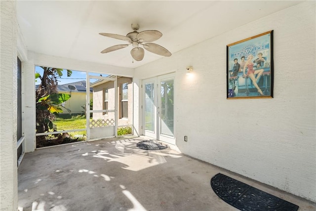 unfurnished sunroom featuring ceiling fan