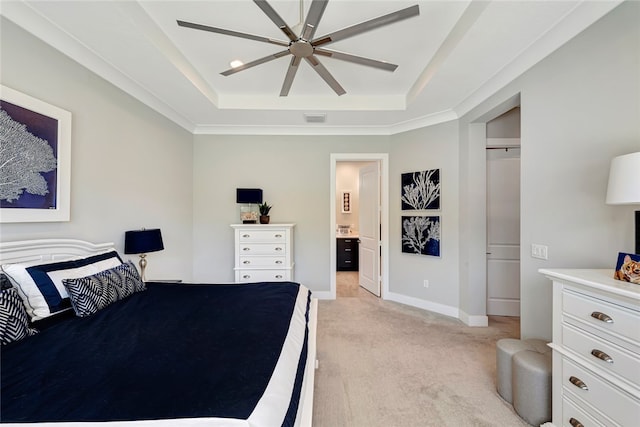 carpeted bedroom with a tray ceiling, ceiling fan, and ensuite bathroom