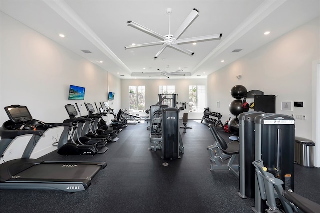 gym featuring a raised ceiling and ceiling fan