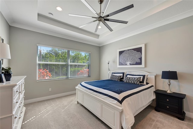 carpeted bedroom featuring a raised ceiling, ceiling fan, and ornamental molding