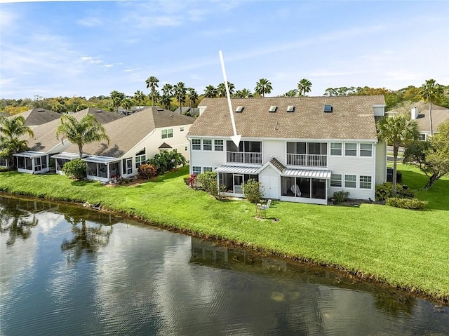 back of house featuring a lawn and a water view