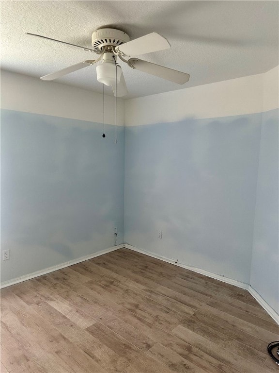 spare room featuring hardwood / wood-style flooring, a textured ceiling, and ceiling fan