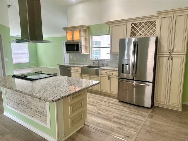 kitchen featuring island range hood, cream cabinets, stainless steel appliances, sink, and light hardwood / wood-style flooring