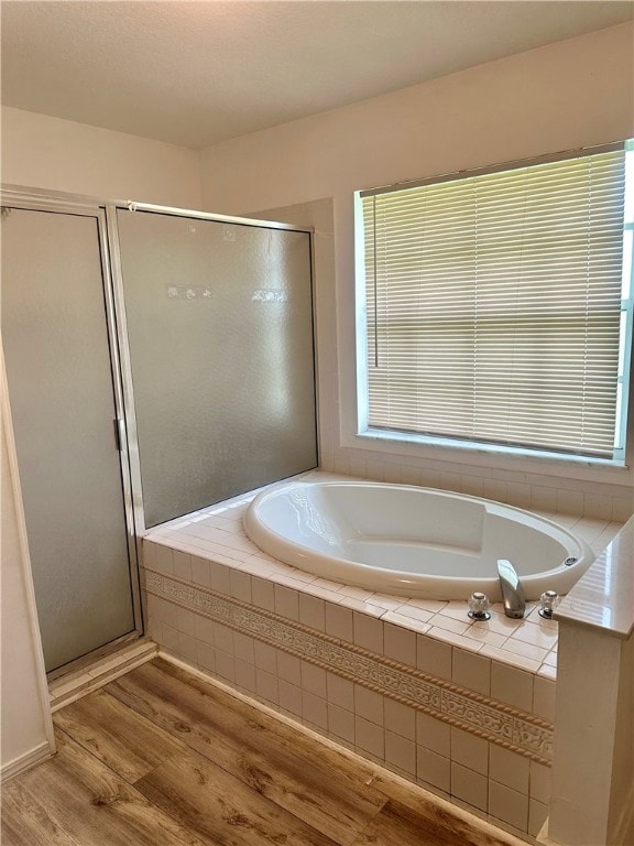 bathroom featuring wood-type flooring and independent shower and bath