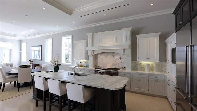 kitchen featuring white cabinets, premium appliances, sink, and ornamental molding