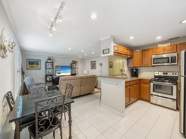 2800 Indian River Blvd Unit J1, Vero Beach, FL 32960 - kitchen with stainless steel appliances, crown molding, a peninsula, tasteful backsplash, and light stone countertops