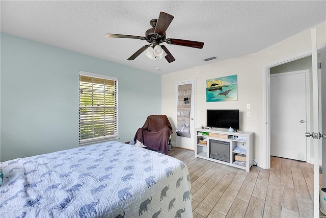 1420 18th Ave SW, Vero Beach, FL 32962 - bedroom featuring light wood-style floors, a textured ceiling, and ceiling fan