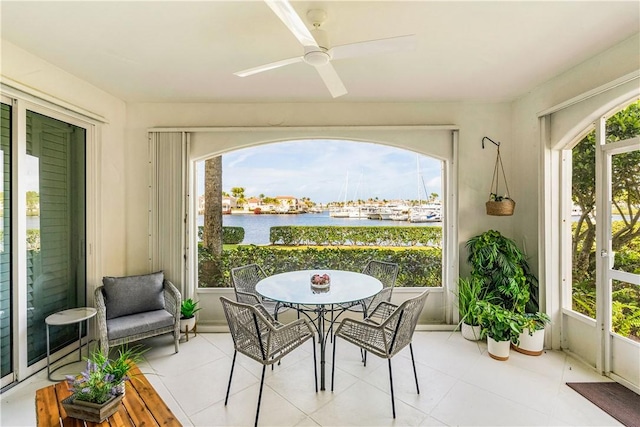 sunroom with a water view, ceiling fan, and a wealth of natural light