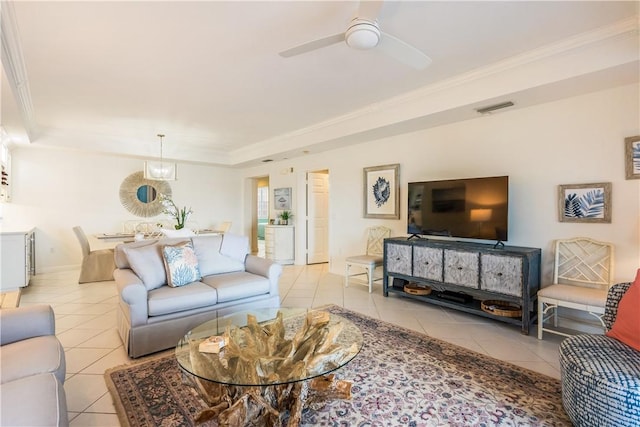 living area with crown molding, light tile patterned floors, a raised ceiling, visible vents, and ceiling fan