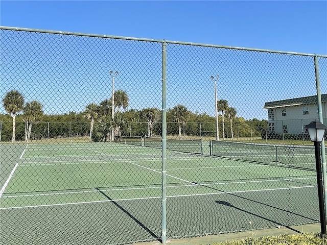 view of tennis court featuring fence