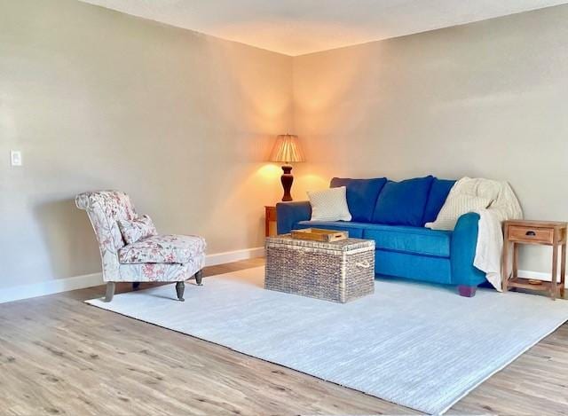 living area with baseboards and wood finished floors