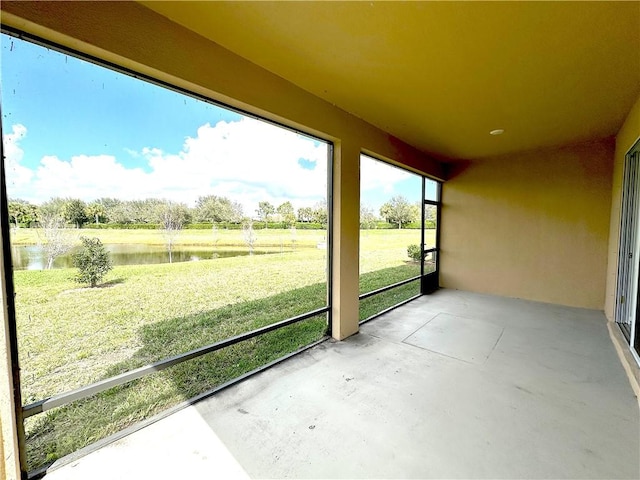 unfurnished sunroom featuring a water view