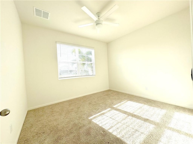 carpeted empty room with ceiling fan, visible vents, and baseboards