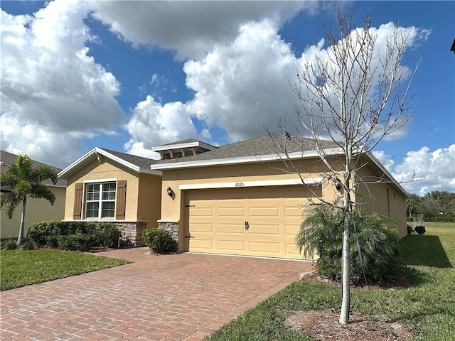 2025 Amazon Way SW, Vero Beach, FL 32962 - view of front facade with stone siding, decorative driveway, an attached garage, stucco siding, and a front lawn