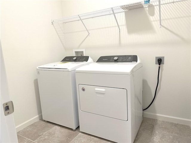 washroom with washing machine and dryer, laundry area, and baseboards