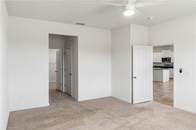 2025 Amazon Way SW, Vero Beach, FL 32962 - unfurnished bedroom featuring light carpet, baseboards, and a ceiling fan