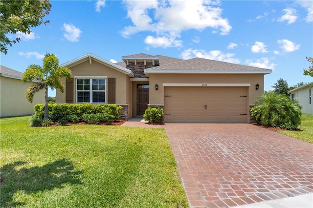 2025 Amazon Way SW, Vero Beach, FL 32962 - view of front of home featuring stucco siding, decorative driveway, a front lawn, a garage, and stone siding