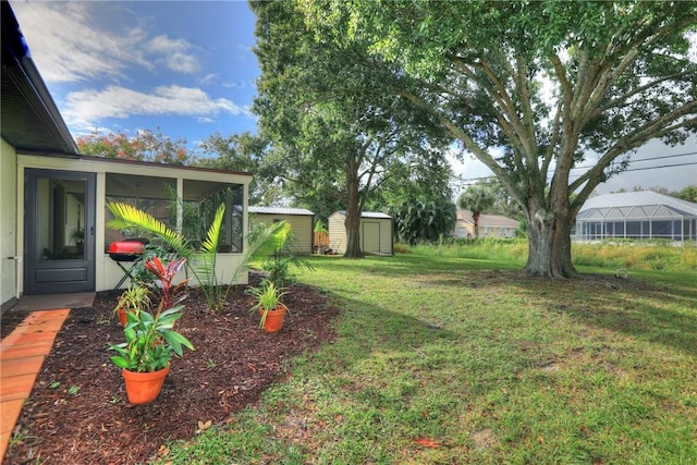 view of yard with a storage shed, an outbuilding, and a sunroom