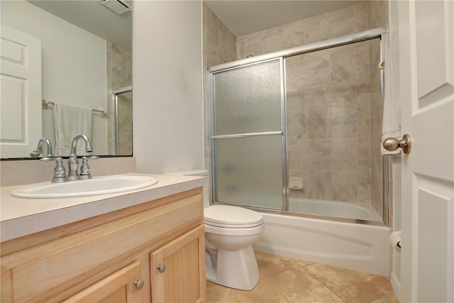 full bathroom featuring vanity, visible vents, toilet, bath / shower combo with glass door, and tile patterned floors