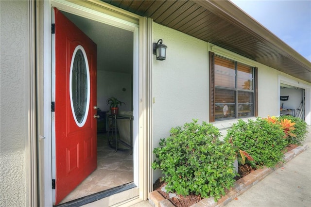 view of exterior entry with stucco siding