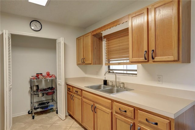kitchen featuring light countertops, a sink, and light tile patterned flooring
